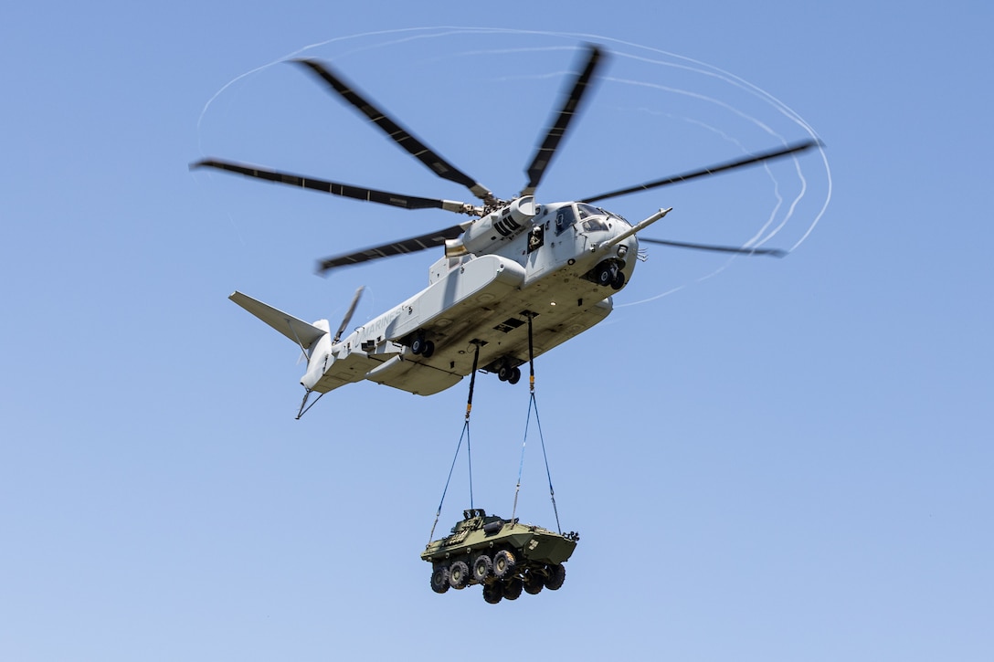 A CH-53K King Stallion helicopter assigned to Marine Operational Test and Evaluation Squadron (VMX) 1 transports a Light Armored Vehicle 25.