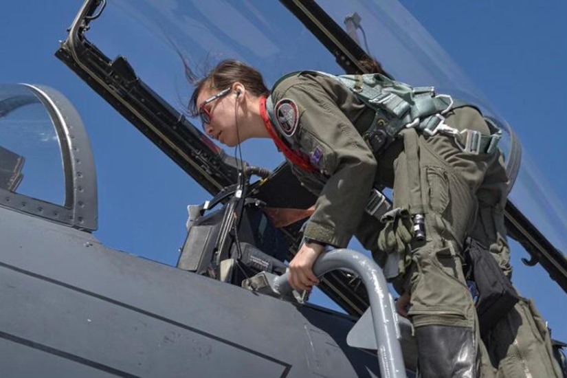 An airman climbs into a jet.