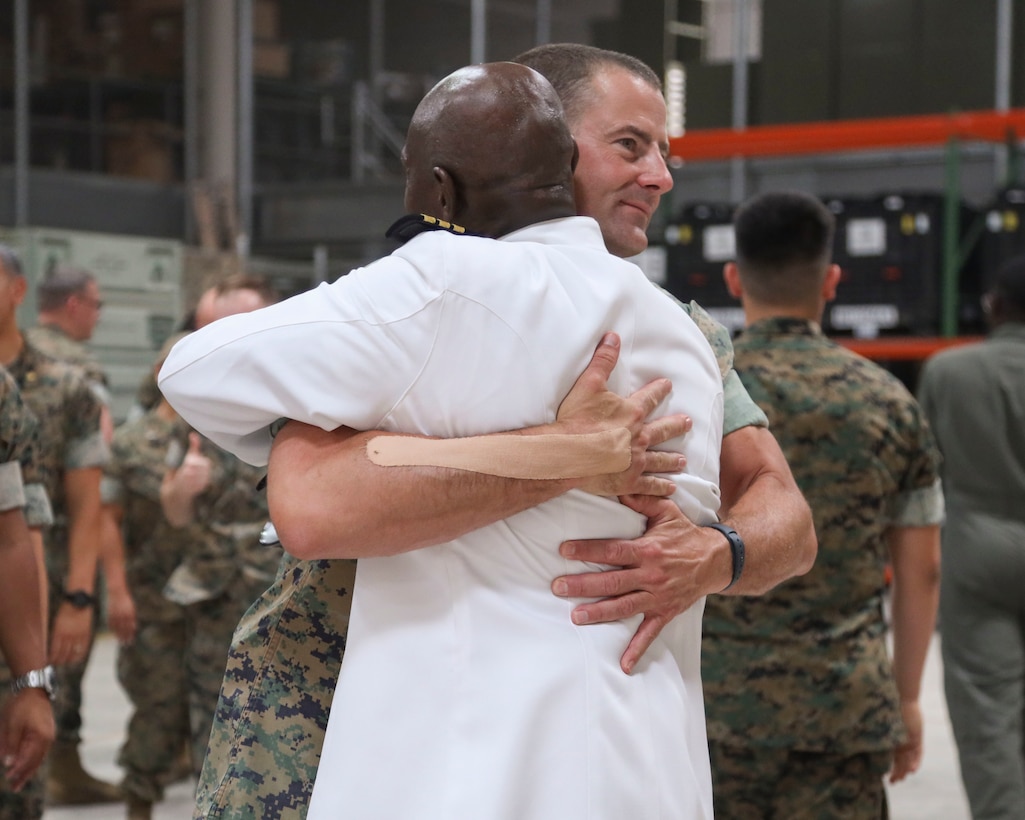 U.S. Navy Cmdr. Devon Foster, chaplain, Marine Aircraft Group 13 (MAG-13), 3rd Marine Aircraft Wing, is congratulated by Marines and Sailors of MAG-13 after his promotion ceremony at Marine Corps Air Station Yuma, Arizona, June 29, 2022.