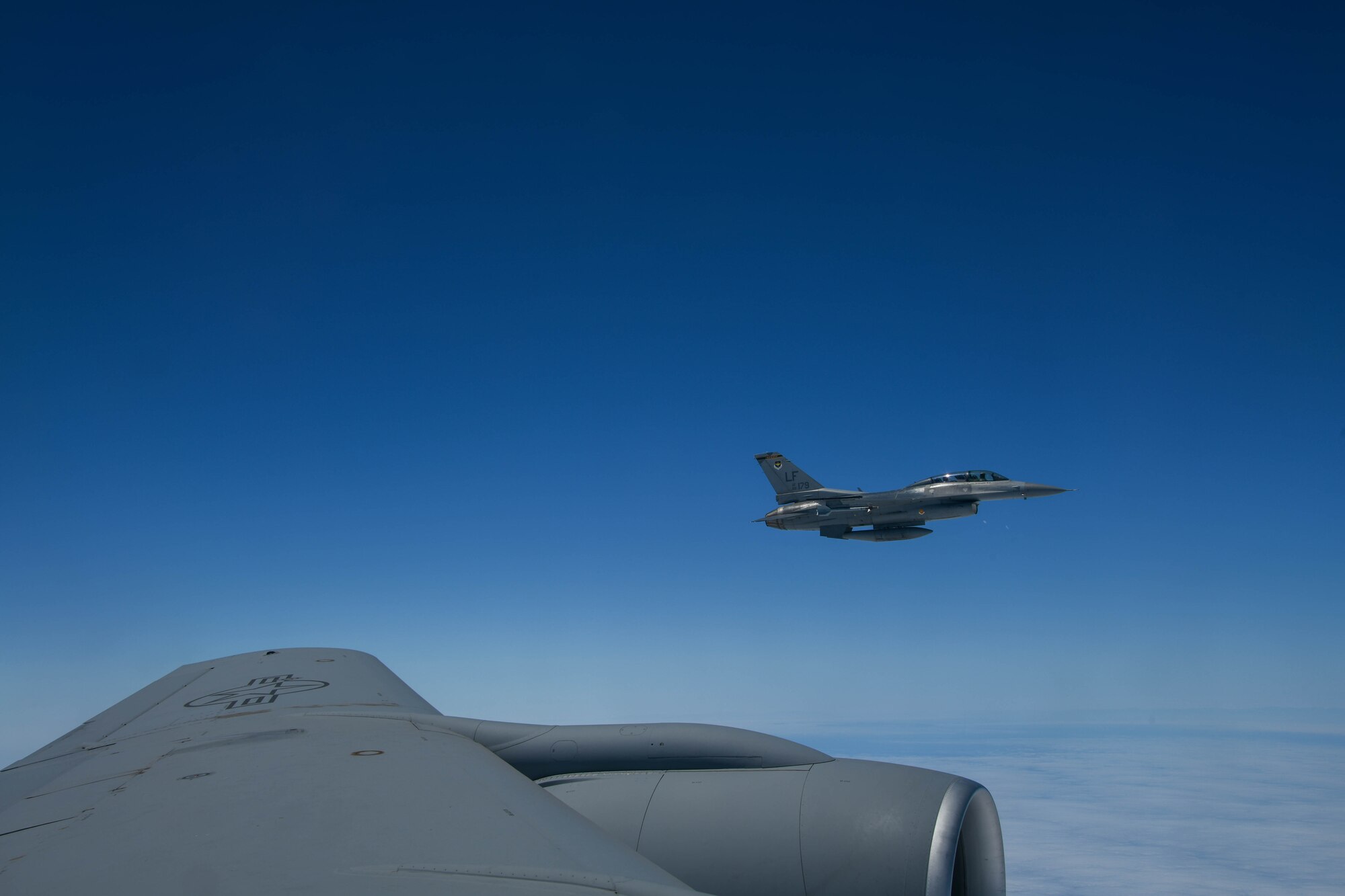 A U.S. Air Force F-16 Fighting Falcon from the 310th Fighter Squadron at Luke Air Force Base, Arizona, waits to be refueled by a KC-135 Stratotanker, July 11, 2022. The F-16s were conducting training with Marine Corps F/A-18 Hornets out of Marine Corps Air Station Miramar, California. (U.S. Air Force photo by Airman 1st Class Trenton Jancze)