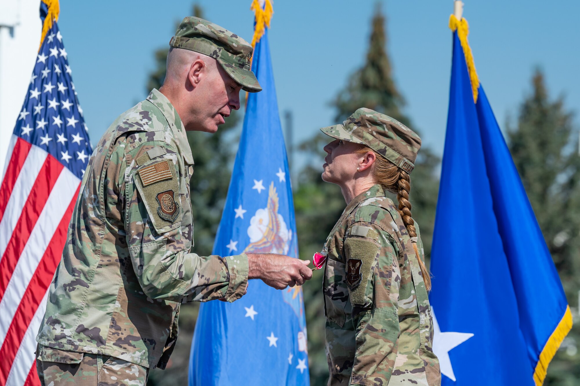 Maj. Gen. Michael Lutton, left, 20th Air Force commander, pins a Legion of Merit medal onto the lapel of Col. Anita Feugate Opperman, right, 341st Missile Wing outgoing commander, during a change of command ceremony July 18, 2022, at Malmstrom Air Force Base, Mont.