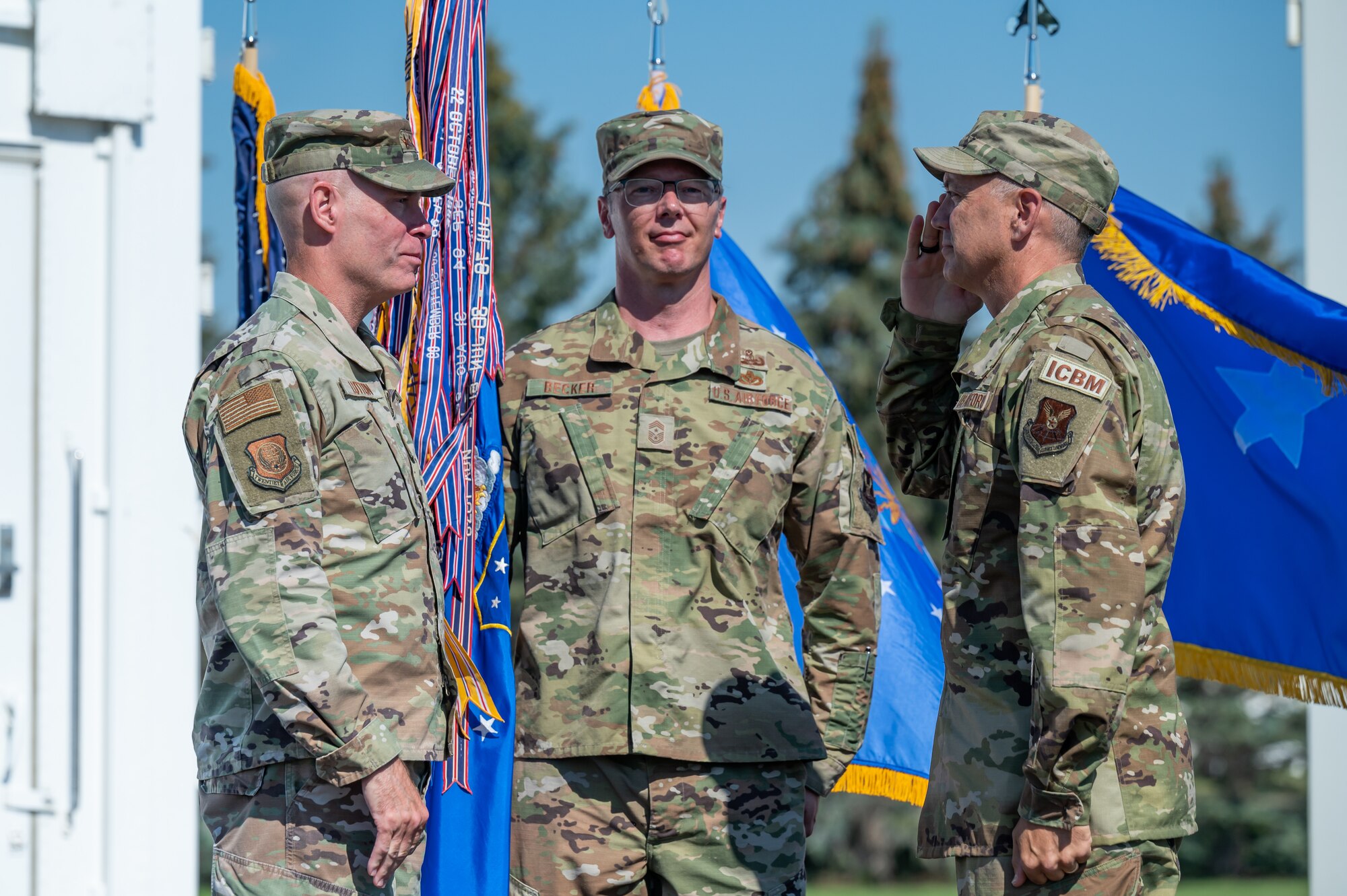 Col. Barry Little, right, accepts command of the 341st Missile Wing from Maj. Gen. Michael Lutton, left, 20th Air Force commander, while Chief Master Sgt. Michael Becker, center, 341st MW command chief and ceremony guidon bearer, looks on during a change of command ceremony July 18, 2022, at Malmstrom Air Force Base, Mont.