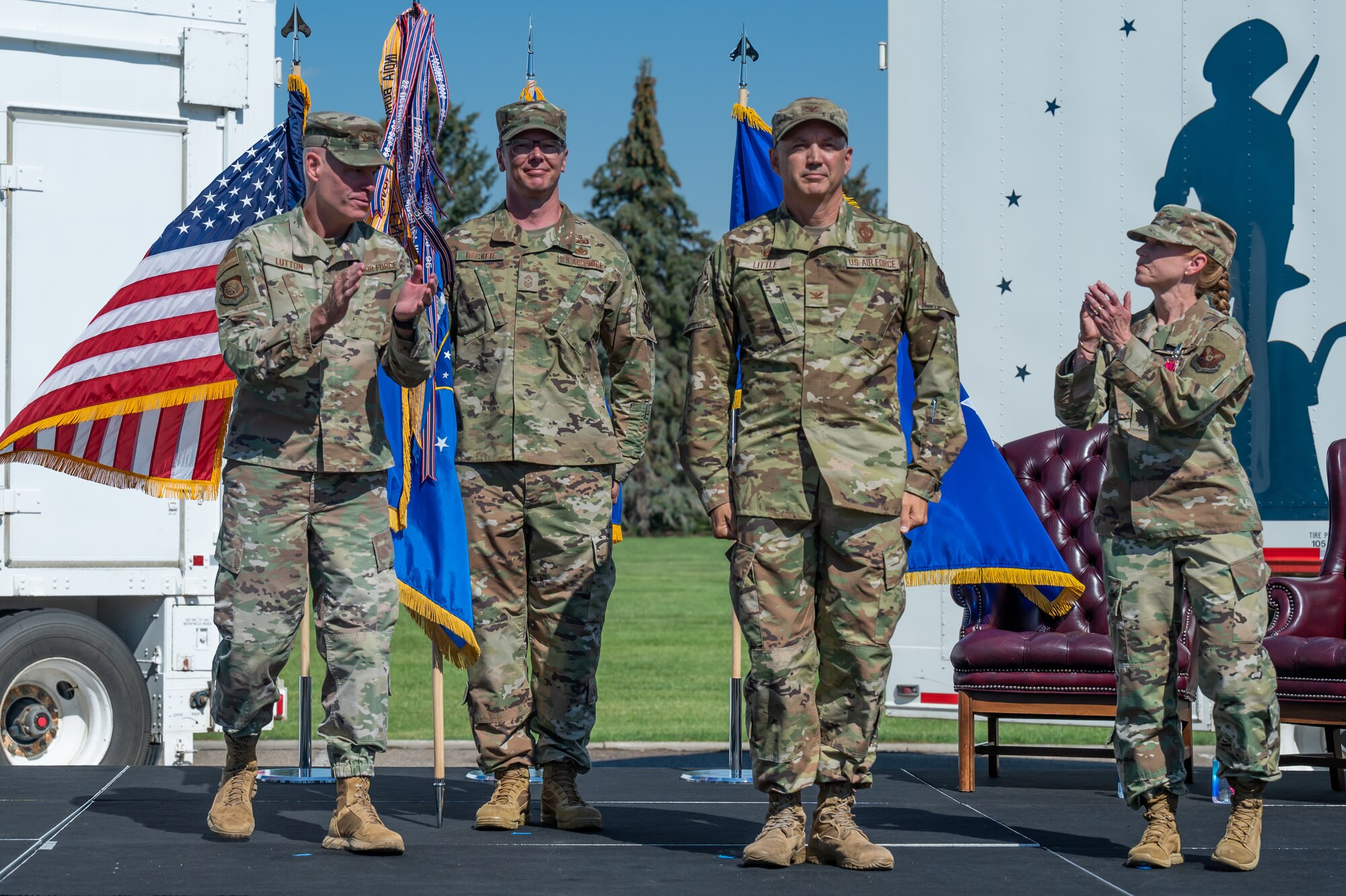 Maj. Gen. Michael Lutton, far left, 20th Air Force commander and Col. Anita Feugate Opperman, far right, 341st Missile Wing outgoing commander, applaud Col. Barry Little, right center, 341st Missile Wing incoming commander, while Chief Master Sgt. Michael Becker, left center, 341st MW command chief, looks on during a change of command ceremony July 18, 2022, at Malmstrom Air Force Base Mont.