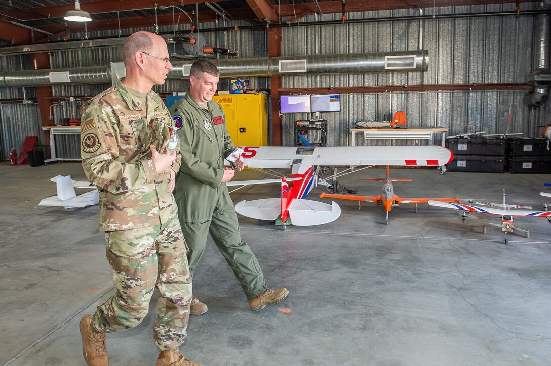 Lt. Col. Adam Brooks, Emerging Technology Combined Test Force commander, briefs Gen. Duke Z. Richardson, Air Force Materiel Command commander, on the ET-CTF mission as they walk past some of the CTF’s fleet of sUAS (small Unmanned Aerial System) test beds at Edwards Air Force Base, California, July 13. (U.S. Air Force photo by James West)