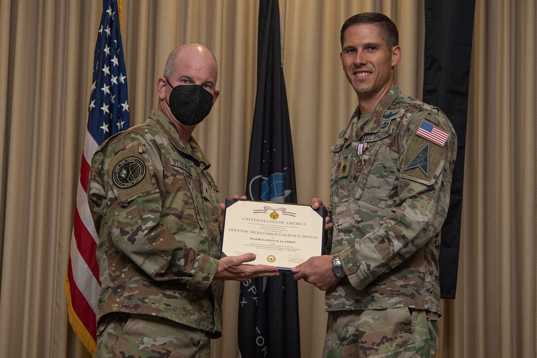 Two military members in uniform both holding a certificate and smiling