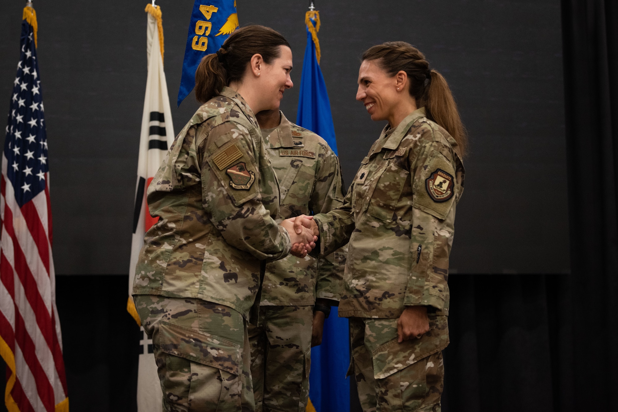 Col. Amanda Figueroa, 694th Intelligence, Surveillance and Reconnaissance Group commander, congratulates Lt. Col. Megan Davis, 303rd Intelligence Squadron incoming commander, at the squadron’s assumption of command ceremony at Osan Air Base, Republic of Korea, July 18, 2022.