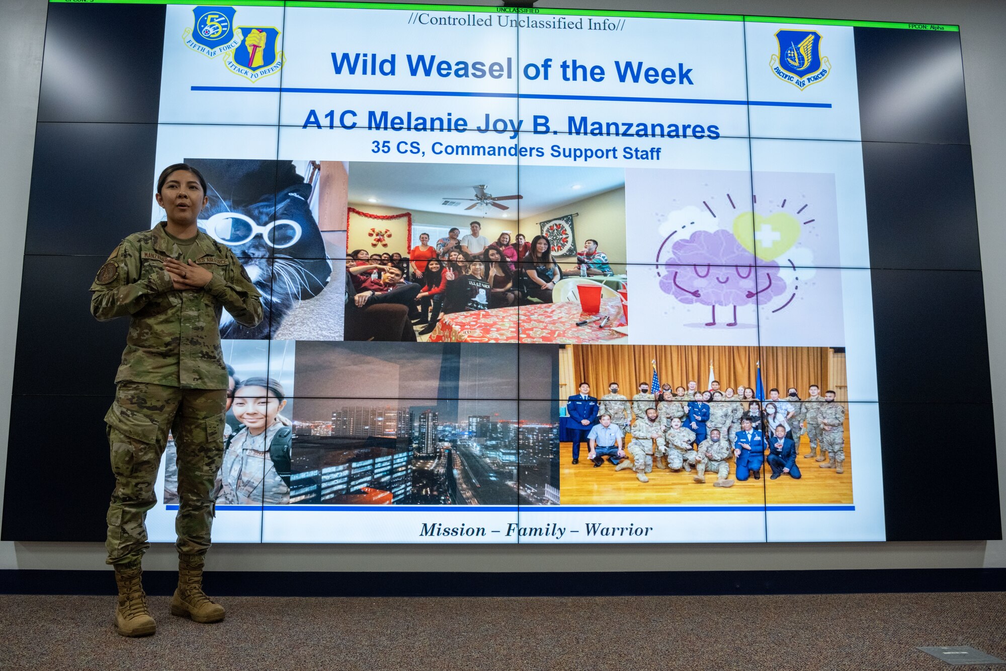 People in uniform attend a briefing indoors while people are recognized