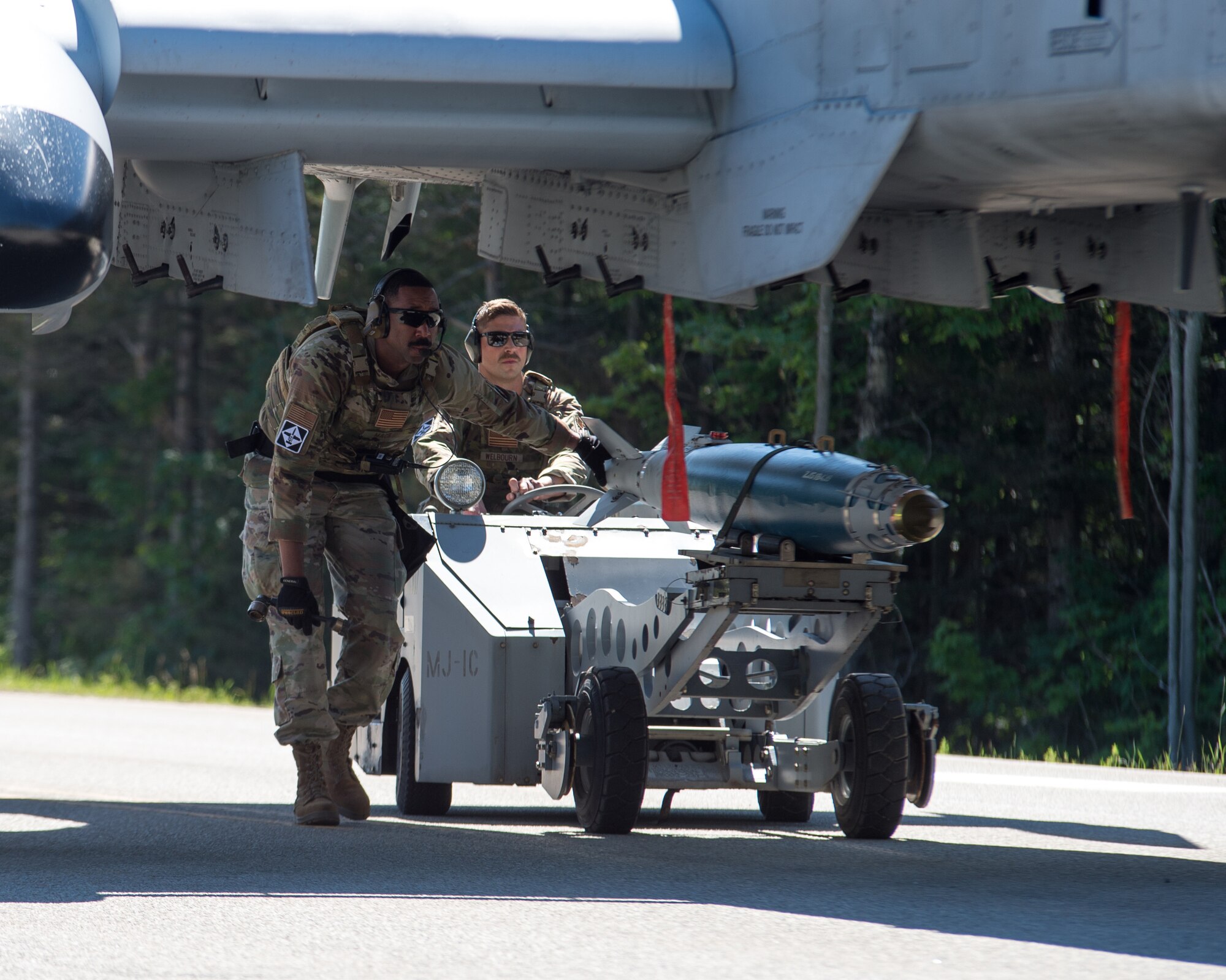 Master Sgt. Joe Mack and Staff Sgt. Brad Welbourn, weapons technicians with the 127th Maintenance Group, Selfridge Air National Guard Base, Michigan, prepare to load dummy missiles on an A-10 Thunderbolt II during a simulated integrated combat turn on a closed portion of M-28 in Alger County, Michigan on June 29, 2022.