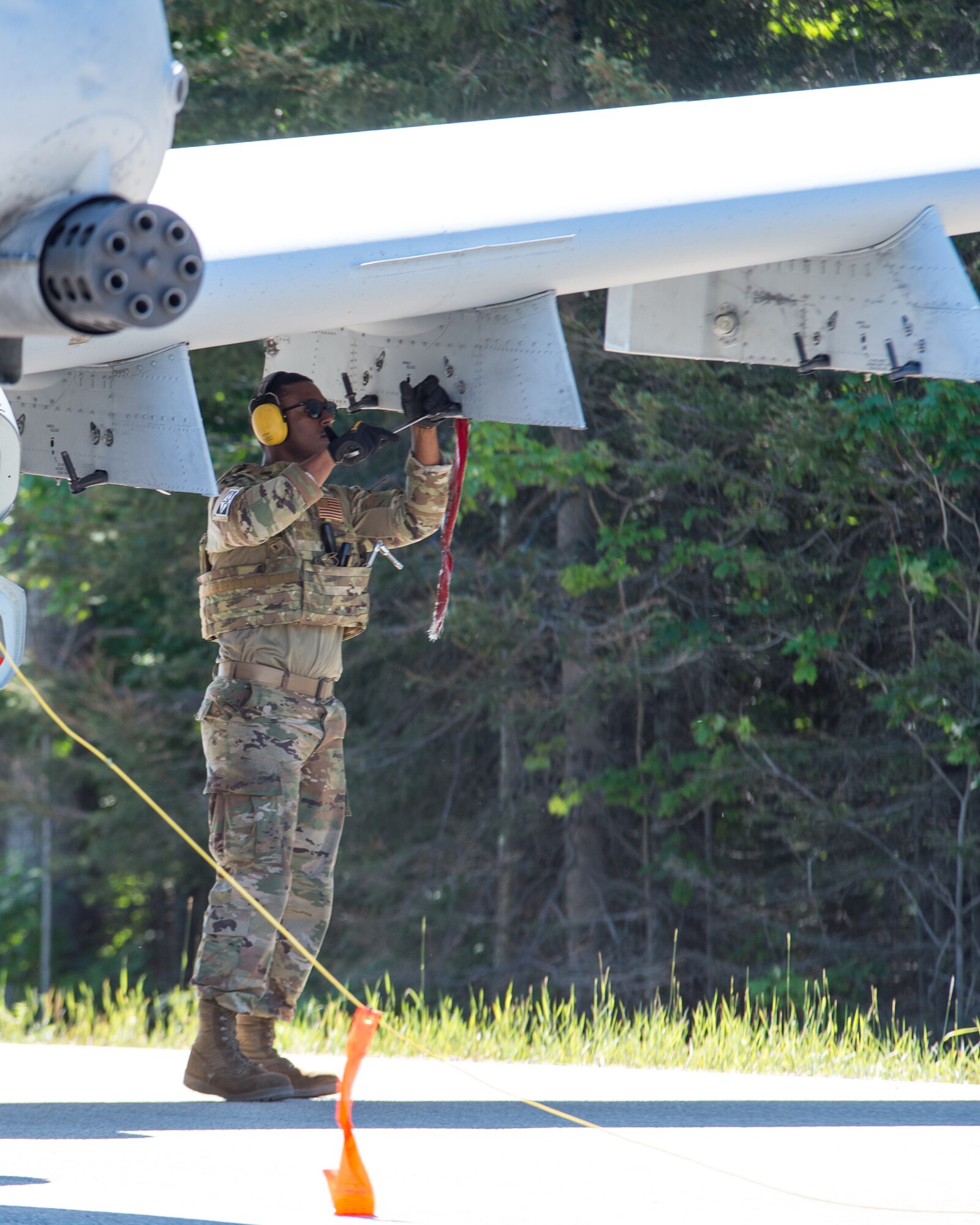 Tech. Sgt. Derrick Mason, a weapons technician with the 127th Maintenance Group, Selfridge Air National Guard Base, Michigan, loads a dummy missile on an A-10 Thunderbolt II during a simulated integrated combat turn on a closed portion of M-28 in Alger County, Michigan on June 29, 2022.