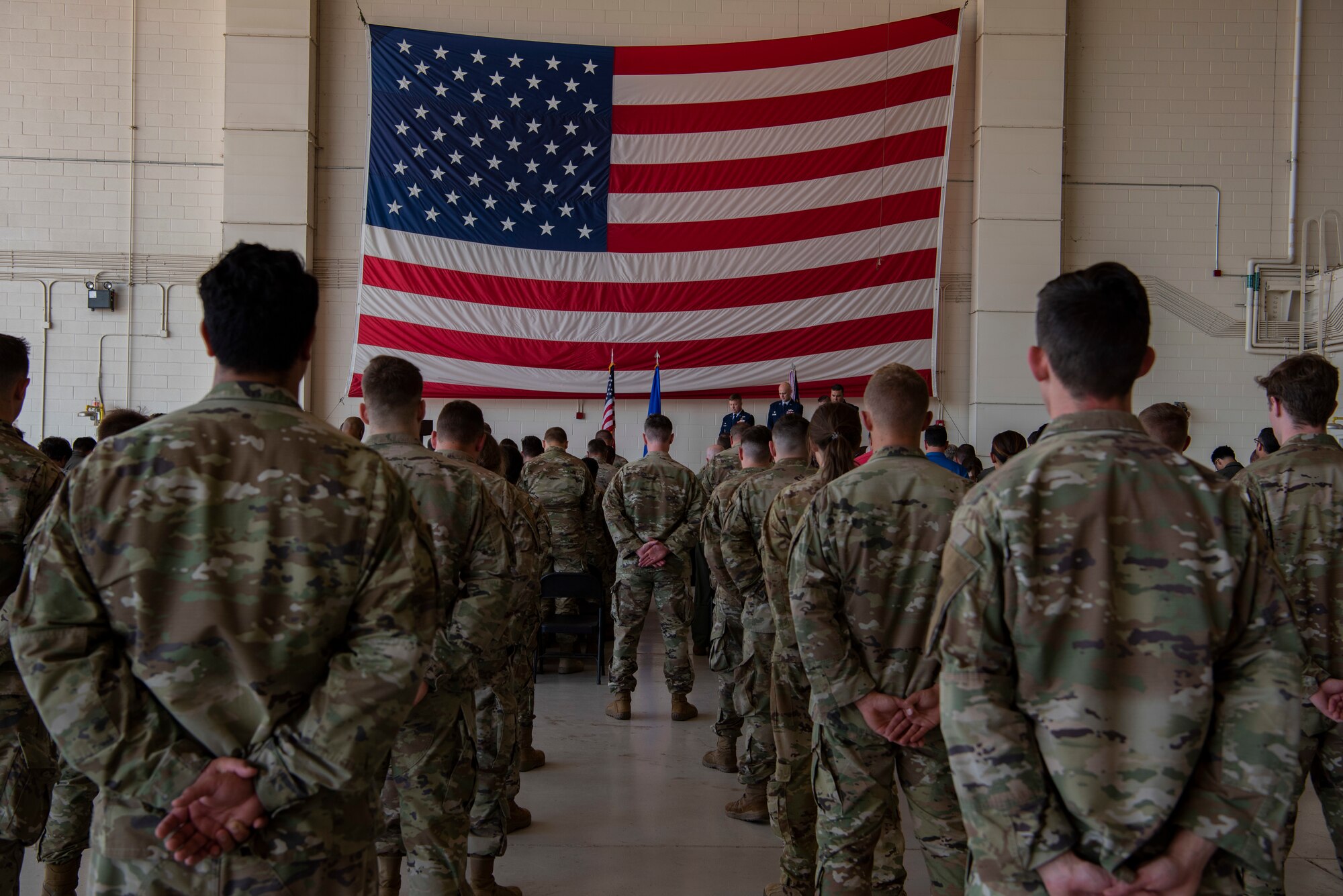 A group of airmen stand at parade rest during the 317th Operation Support Squadron change of command ceremony at Dyess Air Force Base, Texas, June 30, 2022. Changes of command ceremonies are a tradition that formally usher the transfer of authority from one leader to another. (U.S. Air Force photo by Airman 1st Class Ryan Hayman)