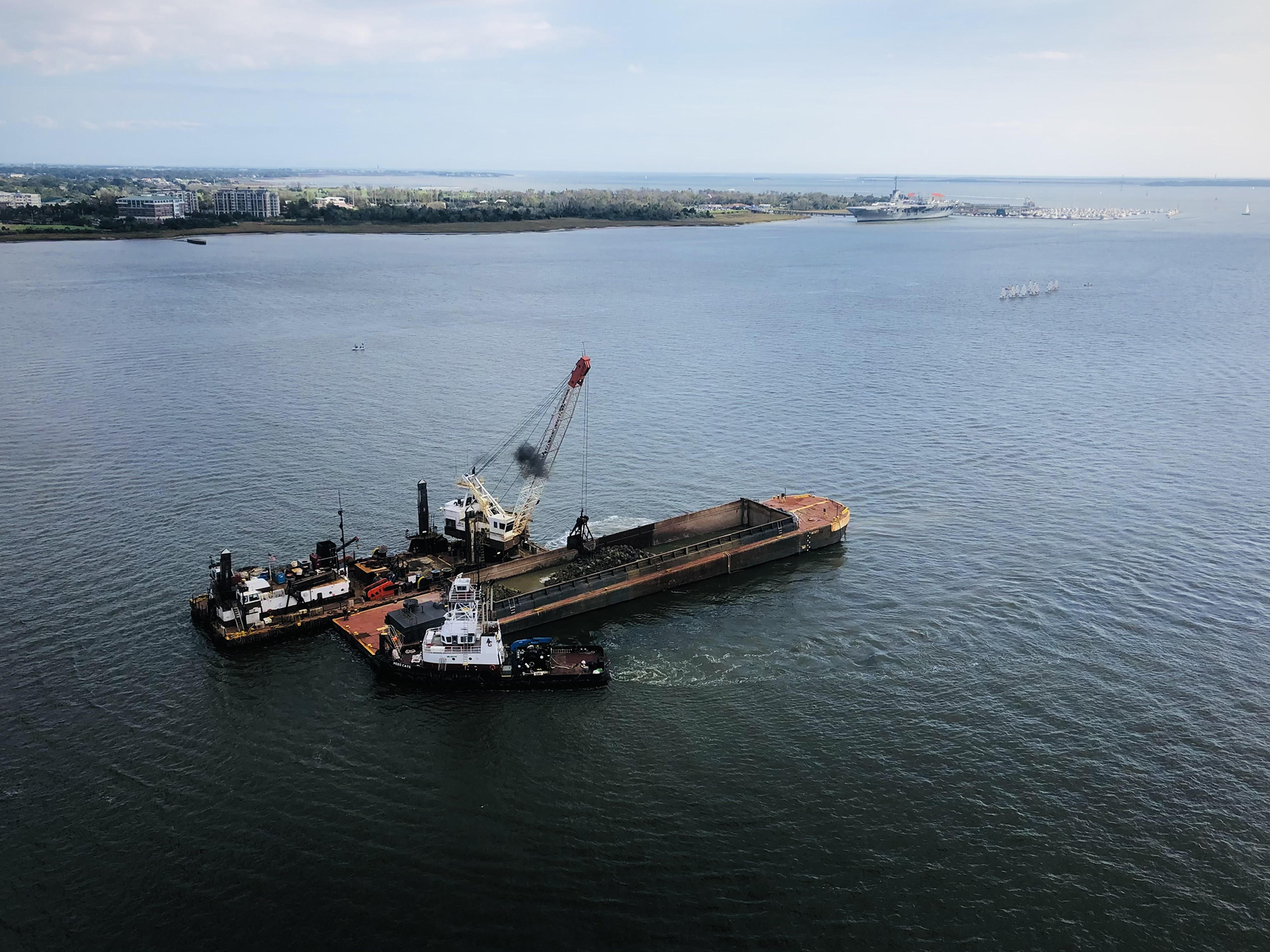 A mechanical dredge moves dredged material from Charleston Harbor to a barge.