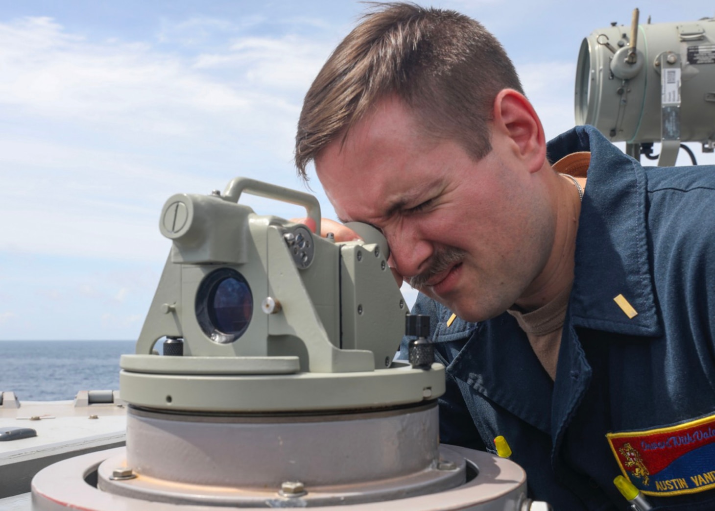 Ensign Austin Van Dusen, from Cincinatti, monitors surface contacts from the bridgewing as the guided-missile destroyer USS Benfold (DDG 65) conducts routine underway operations. Benfold is forward-deployed to the U.S. 7th Fleet area of operations in support of a free and open Indo-Pacific.