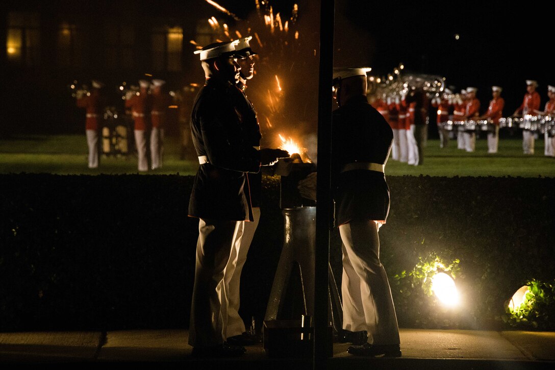 Marines fire a ceremonial battery during an evening parade.