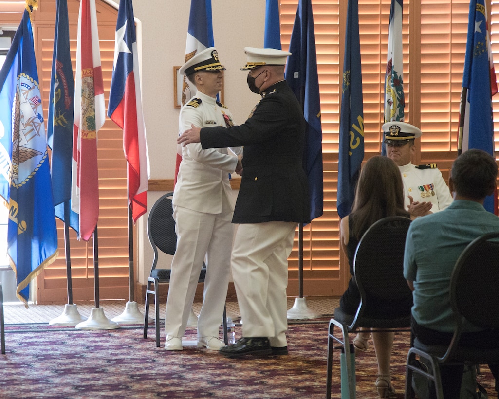 U.S. Marine Corps Col. Charles Dudik, right, commanding officer, Marine Corps Air Station (MCAS) Yuma, Arizona, congratulates U.S. Navy Cmdr. Gareth Montgomery, outgoing director of Installation and Logistics (I&L), MCAS Yuma, Arizona, during his retirement ceremony aboard the installation, July 11, 2022.