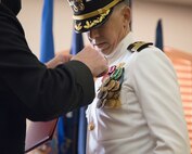 U.S. Navy Cmdr. Gareth Montgomery, outgoing director of Installation and Logistics (I&L), Marine Corps Air Station Yuma, Arizona, is awarded the Meritorious Service Medal during his retirement ceremony aboard the installation, July 11, 2022. Montgomery directed I&L for two years and retired after 22 years of service. (U.S. Marine Corps photo by Lance Cpl. Jade Venegas)