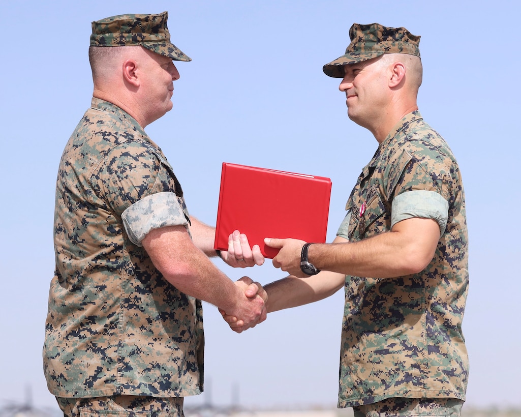 U.S. Marine Corps Lt. Col. Robert Reinoehl, right, outgoing commanding officer, Headquarters and Headquarters Squadron (H&HS), Marine Corps Air Station (MCAS) Yuma, Arizona, is awarded the Meritorious Service Medal by Col. Charles Dudik, commanding officer, MCAS Yuma, during a change of command ceremony aboard the installation, June 30, 2022.