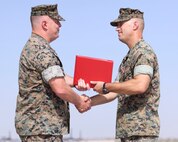 U.S. Marine Corps Lt. Col. Robert Reinoehl, right, outgoing commanding officer, Headquarters and Headquarters Squadron (H&HS), Marine Corps Air Station (MCAS) Yuma, Arizona, is awarded the Meritorious Service Medal by Col. Charles Dudik, commanding officer, MCAS Yuma, during a change of command ceremony aboard the installation, June 30, 2022. Reinoehl commanded H&HS for two years and relinquished command to Lt. Col. Michael Hayes, previously the MCAS Yuma operations officer. (U.S. Marine Corps photo by Lance Cpl. Jade Venegas)