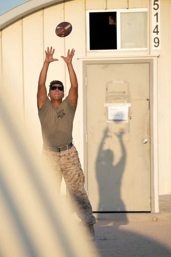 U.S. Marine Corps Lance Cpl. Romeo Delarosa, a semitrailer refueler operator assigned to Bravo Company, Marine Wing Support Squadron 473, 4th Marine Aircraft Wing, from Arlington, Texas, catches a football at Camp Wilson, Marine Corps Air-Ground Combat Center, Twentynine Palms, Calif., during Integrated Training Exercise (ITX) 4-22, July 17, 2022. Reserve Marines and Sailors have come together from across the nation to form an integrated Marine Air-Ground Task Force to take part in a live-fire, combined arms exercise that will better prepare Marine Forces Reserve in its mission to augment and reinforce the Active Component. (U.S. Marine Corps Video by Cpl. James Stanfield)