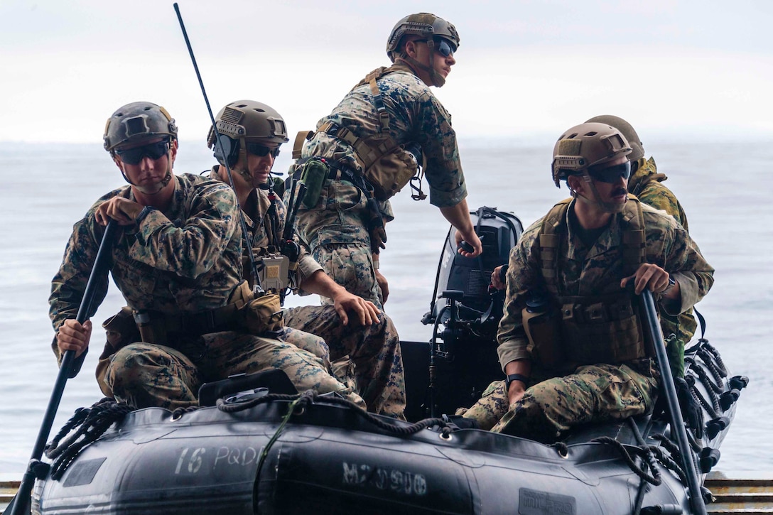 Marines ride in a combat rubber raiding craft.