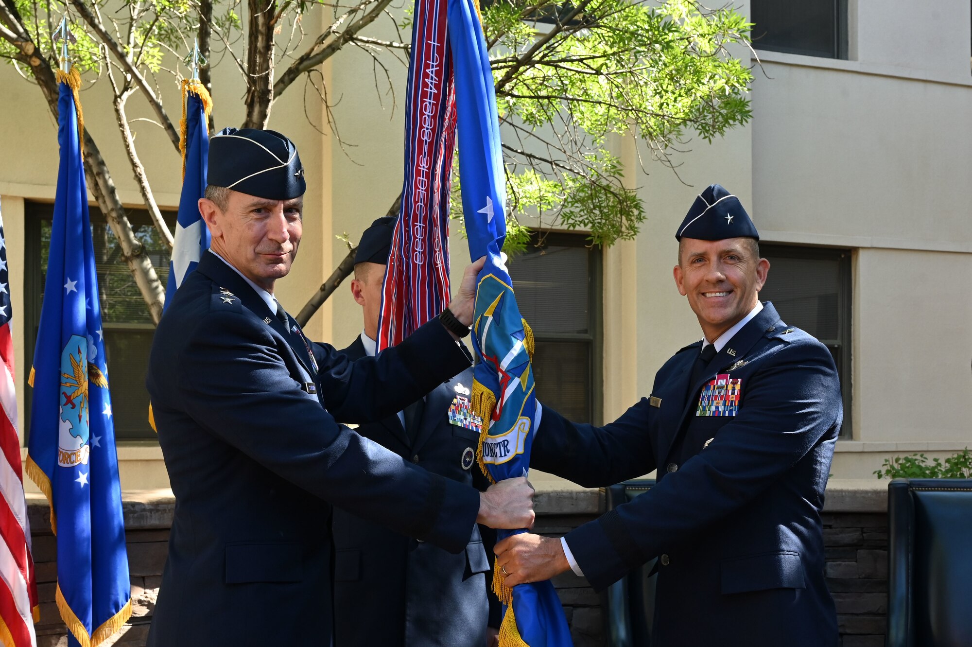 A man passes a guidon to another man.