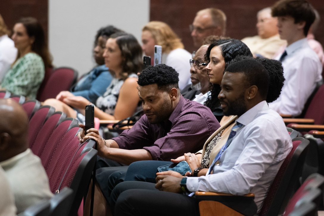 A group of people sitting in a auditorium.