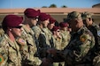 Soldiers stand in a formation and receive their foreign airborne wings.