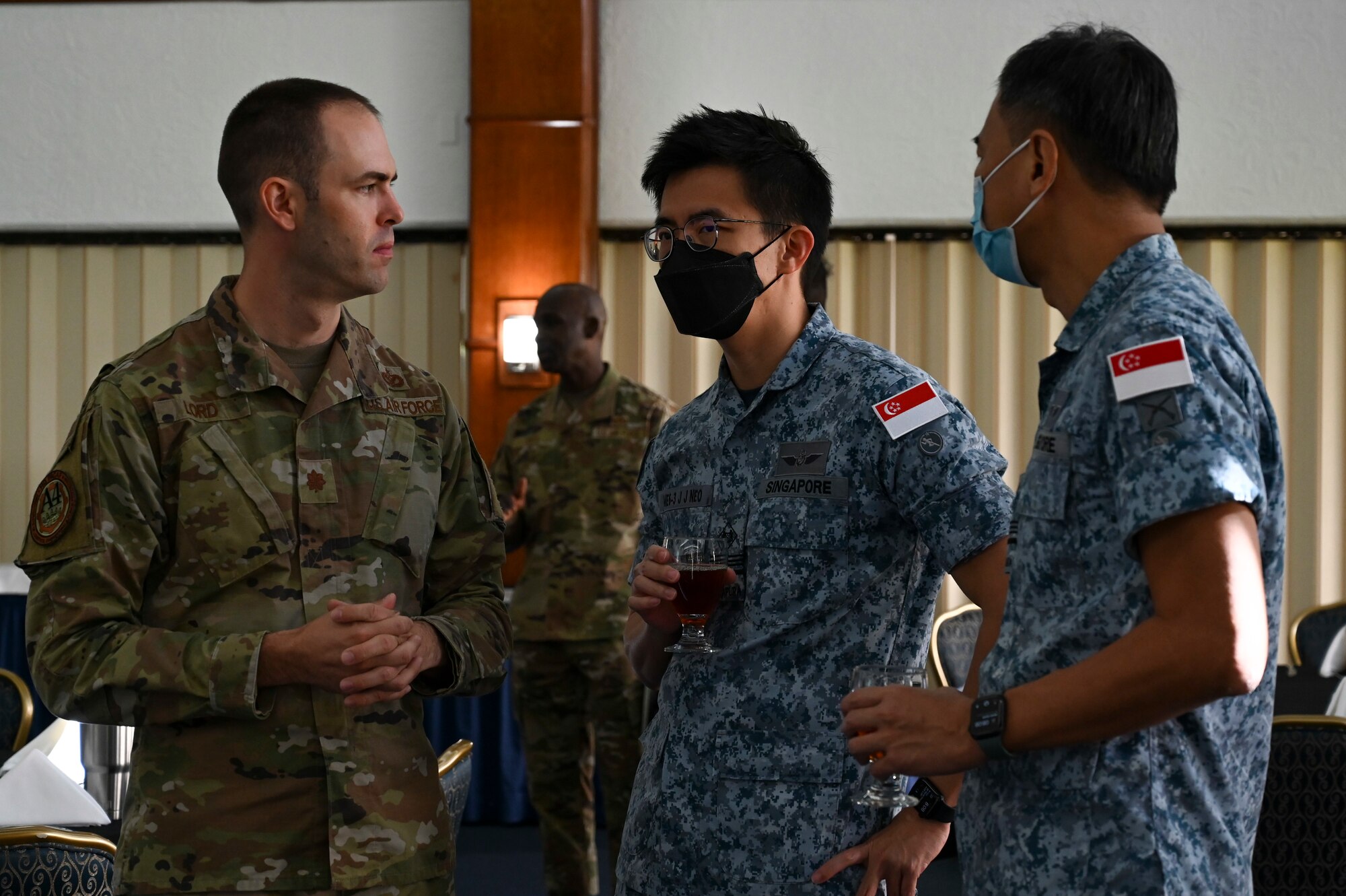 U.S. Air Force Maj. Timothy Lord, Chief of Civil Engineer Readiness Branch, Pacific Air Forces, speaks with members of the Republic of Singapore Air Force during the Pacific Unity Multi-Lateral Civil Engineer Key Leader Engagement, June 22, 2022 at Andersen Air Force Base, Guam. Themes during this KLE included topics of shared interest across the allies and partners such as joint capabilities, leveraging expertise in the Total Force, and increased frequency of subject matter expert exchanges and multi-lateral training. (U.S. Air Force Photo by Airman 1st Class Emily Saxton)