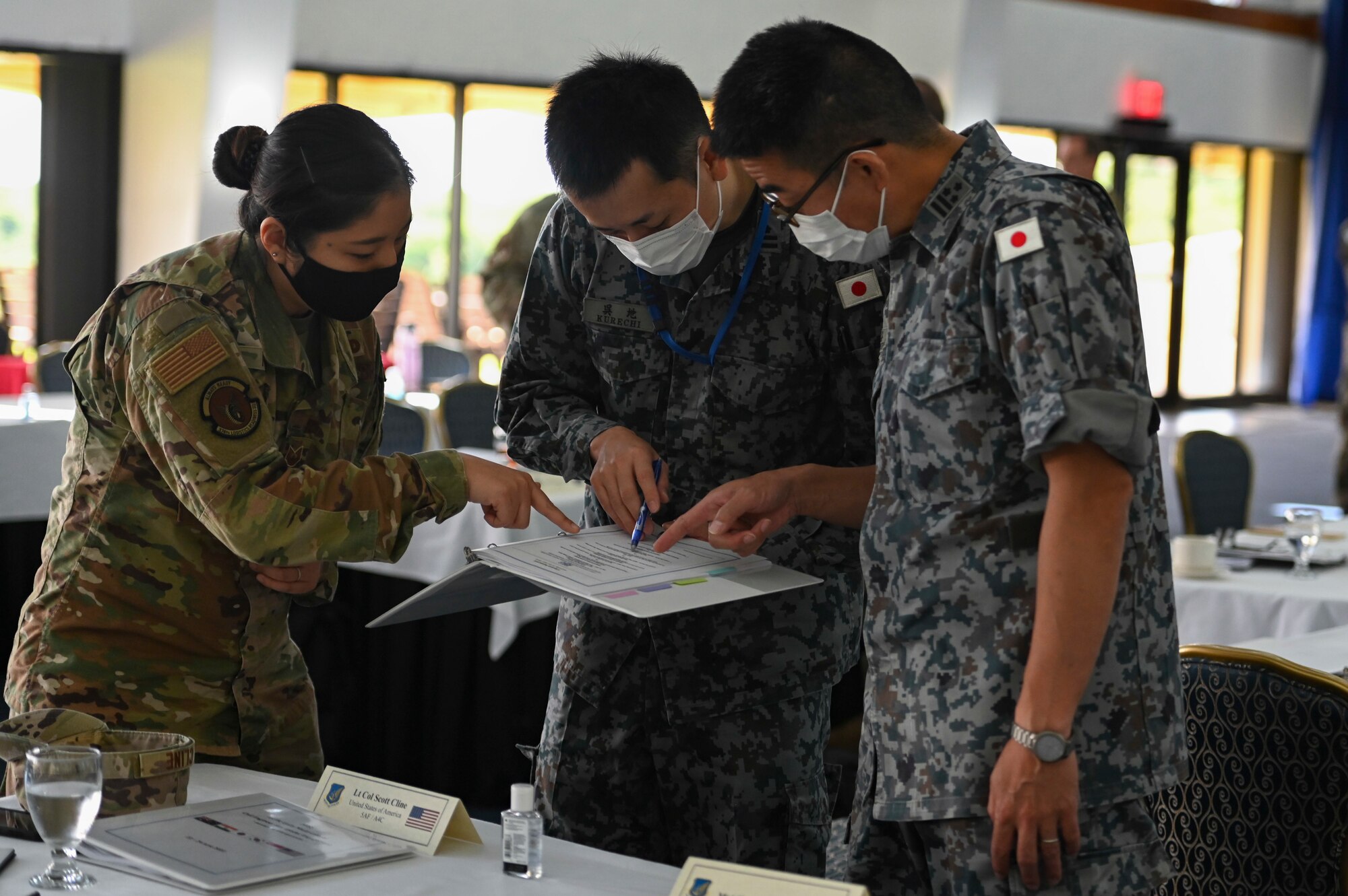 TSgt Kanako Fromm, a U.S. Air Force Language Enabled Airman assigned to the 374th Wing, helps interpret material with members of the Japan Air Self-Defense Force during the Pacific Unity Multi-Lateral Civil Engineer Key Leader Engagement, June 22, 2022 at Andersen Air Force Base, Guam. Themes during this KLE included topics of shared interest across the allies and partners such as joint capabilities, leveraging expertise in the Total Force, and increased frequency of subject matter expert exchanges and multi-lateral training. (U.S. Air Force Photo by Airman 1st Class Emily Saxton)