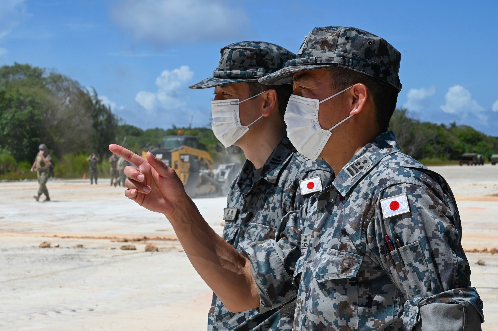Members from the Japan Air Self-Defense Force observe the repair of an airfield runway during the Pacific Unity Multi-Lateral Civil Engineer Key Leader Engagement, June 23, 2022 at Andersen Air Force Base, Guam. Themes during this KLE included topics of shared interest across the allies and partners such as joint capabilities, leveraging expertise in the Total Force, and increased frequency of subject matter expert exchanges and multi-lateral training. (U.S. Air Force Photo by Airman 1st Class Emily Saxton)