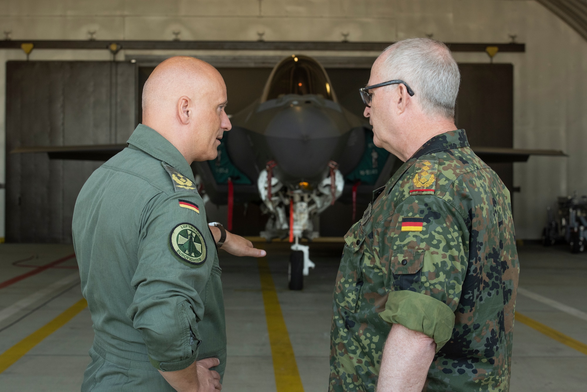 German Gen. Eberhard Zorn, Chief of Defense (center) speaks with U.S. Air Force Lt. Gen. Michael Loh, director, Air National Guard (left) and Lt. Gen. Ingo Gerhartz, chief of the German air force, in front of an F-35A Lightning II fifth generation fighter aircraft assigned to the 315th Fighter Squadron at Spangdahlem Air Base, Germany, July 19, 2022. As Germany's highest-ranking soldier, the Chief of Defense is responsible for the overall military defense concept and he has full command of the armed forces. The 52nd FW works regularly with their NATO partners to strengthen bonds, secure common interests and promote shared values.  (U.S. Air Force photo by Tech. Sgt. Anthony Plyler.)