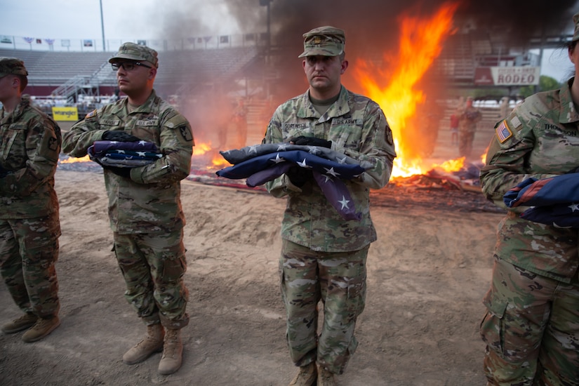 Soldiers hold a flags during a flag retirement ceremony