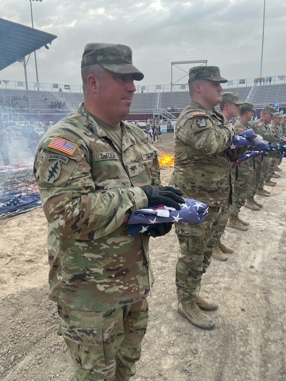 Soldiers holds a flag during a flag retirement ceremony