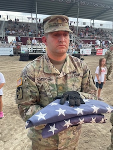 A soldier holds a flag during a flag retirement ceremony