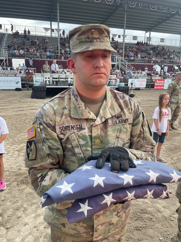 A soldier holds a flag during a flag retirement ceremony