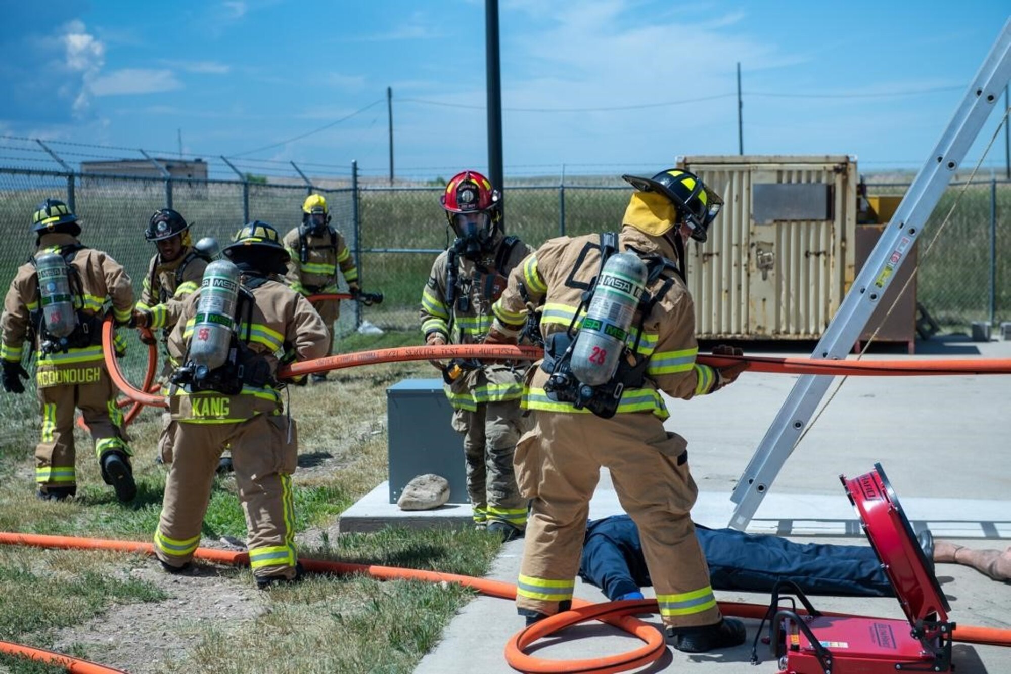 Personnel from the 28th Civil Engineering Squadron Fire Fighting Unit draw a fire hose from a building on Ellsworth Air Force Base, S.D., July 13, 2022.