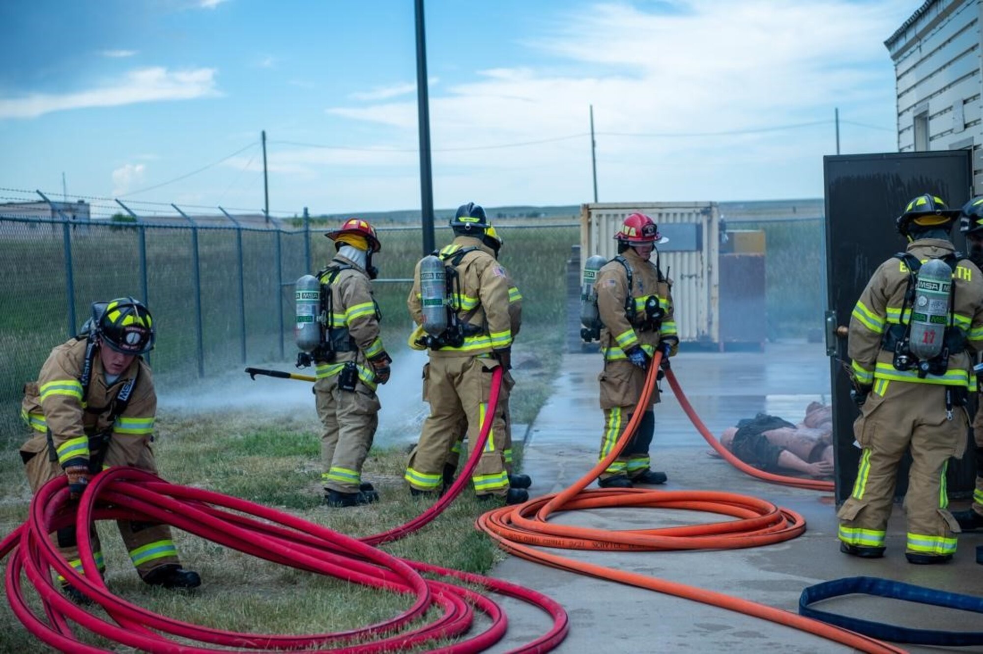 Personnel with the 28th Civil Engineering Squadron Fire Fighting Unit stage fire hoses for use in an exercise on Ellsworth Air Force Base, S.D., July 13, 2022.