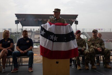 A Soldier stands behind a podium and is addressing an audience.