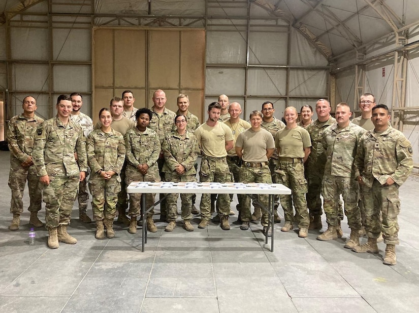 Deployed Soldiers assigned to the 1067th Composite Truck Company stand with service members of allied nations during their multi-day training event. The purpose of the training was to foster partnership with coalition forces and included weapon system familiarization, medical aid, rollover training and presentations from coalition service members. The coalition service members even shared the kind of food that comes in their meals ready to eat (MREs). (U.S. Army photo by 1st Lt. Michael Demboski)