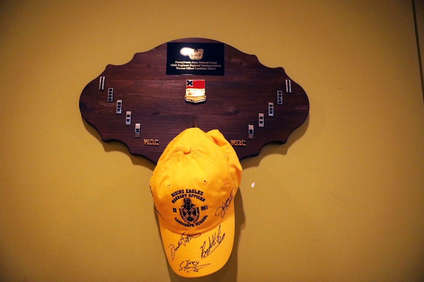The Warrant Officer Candidate School Class 22-301 hat hangs in the dining hall. This hat was presented to the guest of honor during the sign, song and hat ceremony at Fort Indiantown Gap, July 17, 2022. (U.S. Army National Guard photo by Capt. Leanne Demboski)