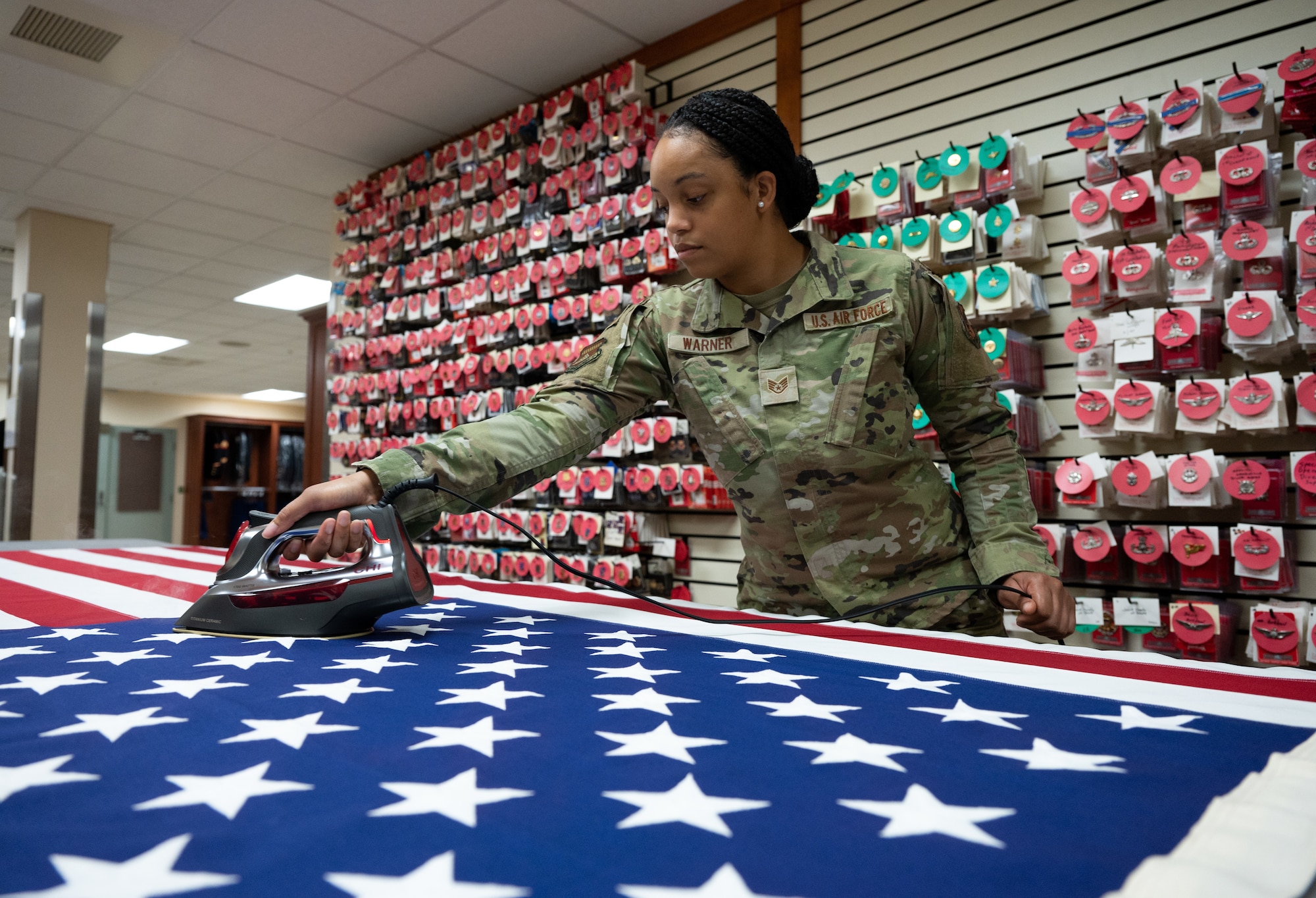 Staff Sgt. Zamiyah Warner, Air Force Mortuary Affairs Operations departures specialist, prepares a U.S. flag at Dover Air Force Base, Delaware, July 14, 2022. Flag preparation consists of ironing the flag, removing any lint and clipping strings. Warner is a reservist deployed to AFMAO from the 512th Memorial Affairs Squadron.  (U.S. Air Force photo by Jason Minto)