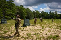 A group of Airmen walking while holding up firearms