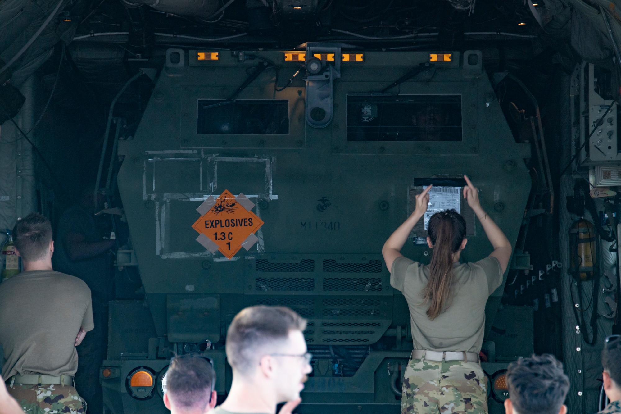 U.S. Air Force Tech. Sgt. Lauren Wood, a loadmaster with Air National Guard, 133rd Airlift Wing, St. Paul, Minnesota, guides a U.S. Marine Corps High-Mobility Artillery Rocket System with 5th Battalion, 11th Marine Regiment, 1st Marine Division, onto a U.S. Air National Guard C130 Hercules in support of exercise Valiant Shield 2022