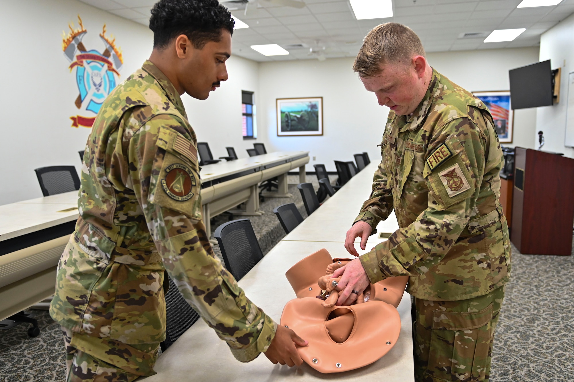 Airman 1st Class Devante Speck and Staff Sgt. Matthew Lester, 14th Civil Engineering Squadron firefighters, explain how they do obstetrician training using a mannequin on July 18, 2022, at Columbus Air Force Base Miss. Obstetrician training is one of the certifications firefighters must complete to become a firefighter as well as additionally reviewing their training annually. (U.S. Air Force photo by Airman 1st Class Jessica Blocher)