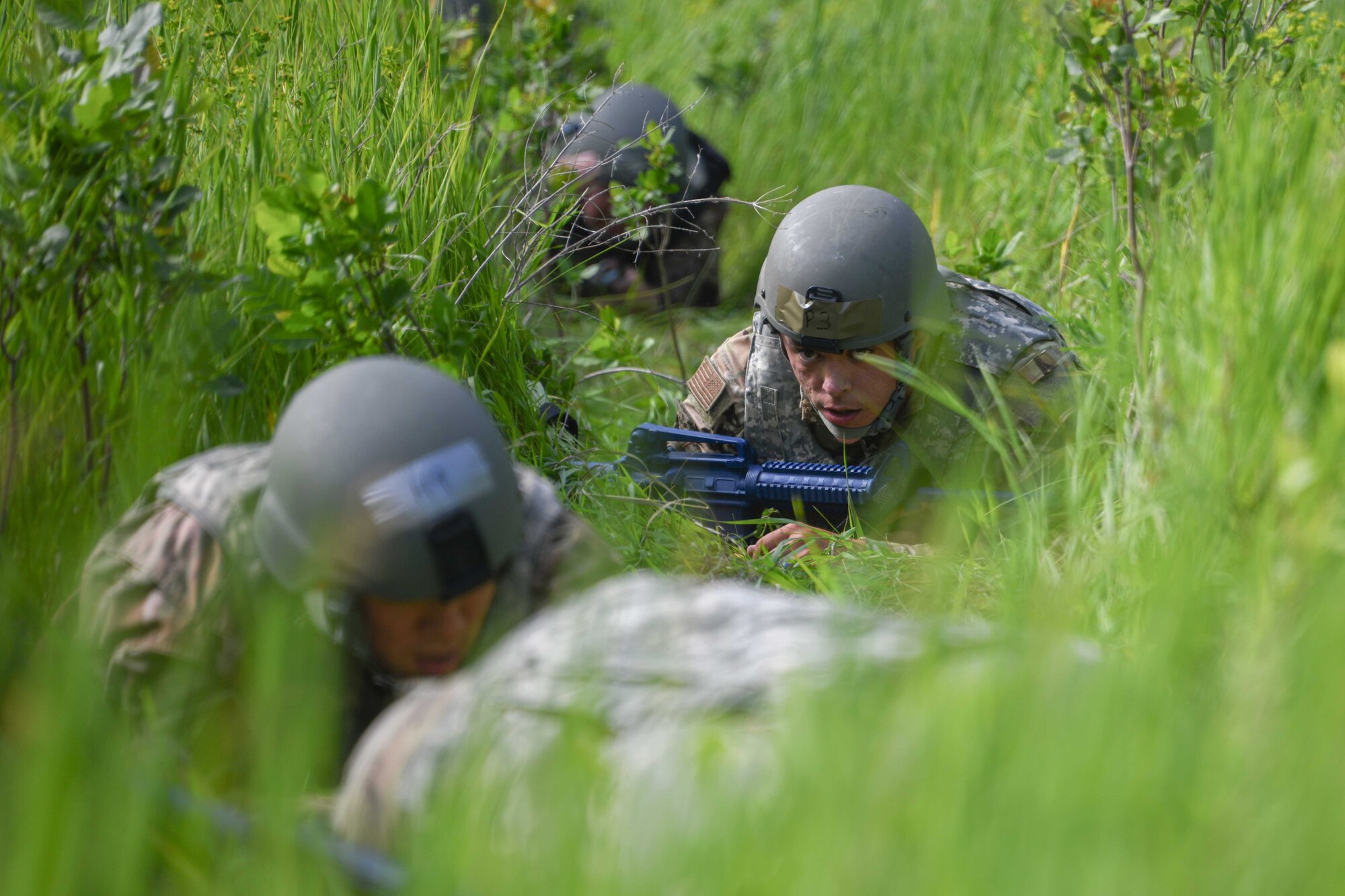 An Airman from the 319th Civil Engineer Squadron engineering supervisor, low crawls during a Prime Base Engineer Emergency Force training on Grand Forks Air Force Base, North Dakota, July 14, 2022. The goal of Prime BEEF training is to create and maintain civil engineer forces capable of completing multiple objectives at any time. (U.S. Air Force photo by Senior Airman Ashley Richards)