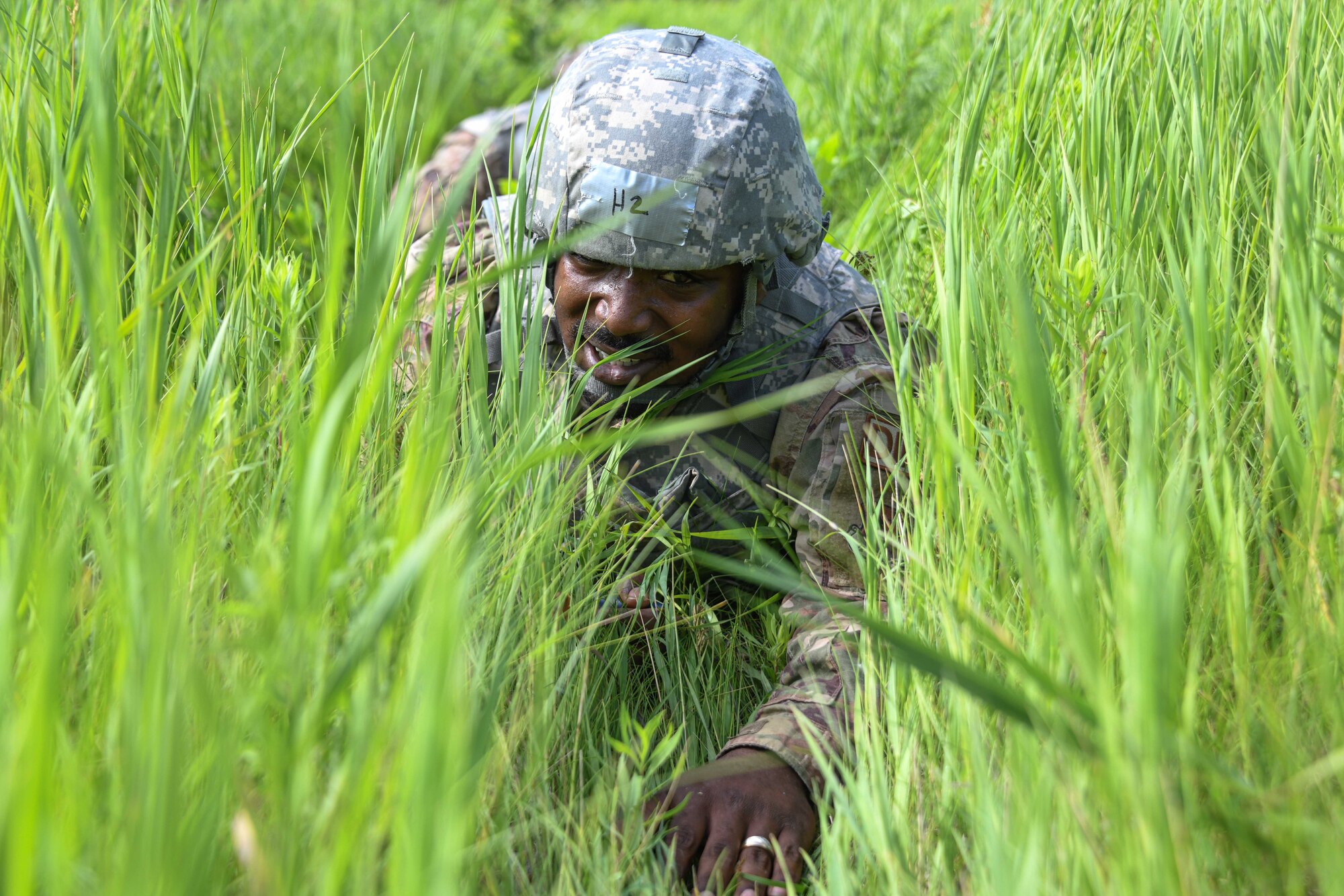 An Airman from the  319th Civil Engineer Squadron engineering supervisor, low crawls during a Prime Base Engineer Emergency Force training on Grand Forks Air Force Base, North Dakota, July 14, 2022. The goal of Prime BEEF training is to create and maintain civil engineer forces capable of completing multiple objectives at any time. (U.S. Air Force photo by Senior Airman Ashley Richards)