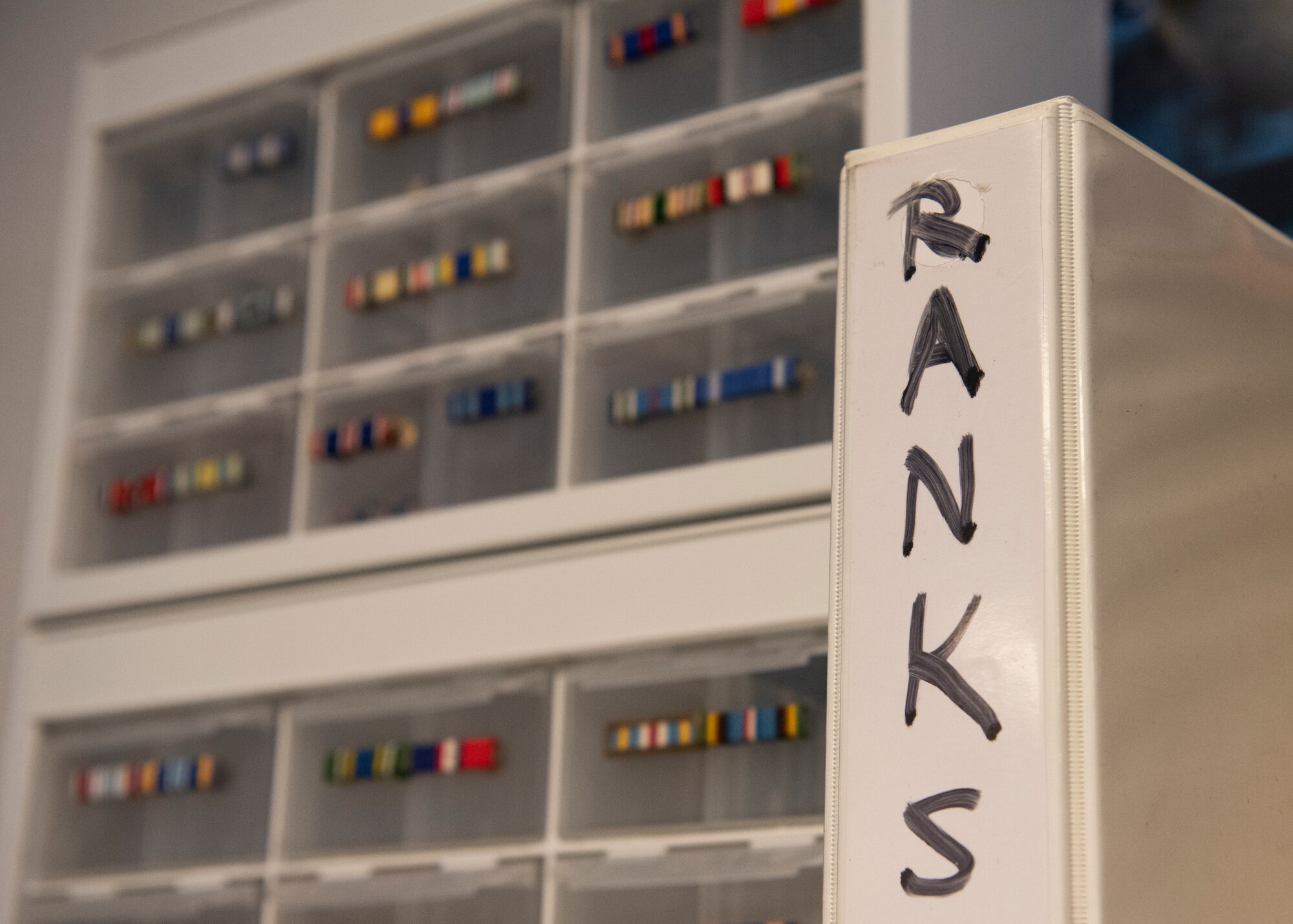 A binder with the word ranks and drawers with various ribbons