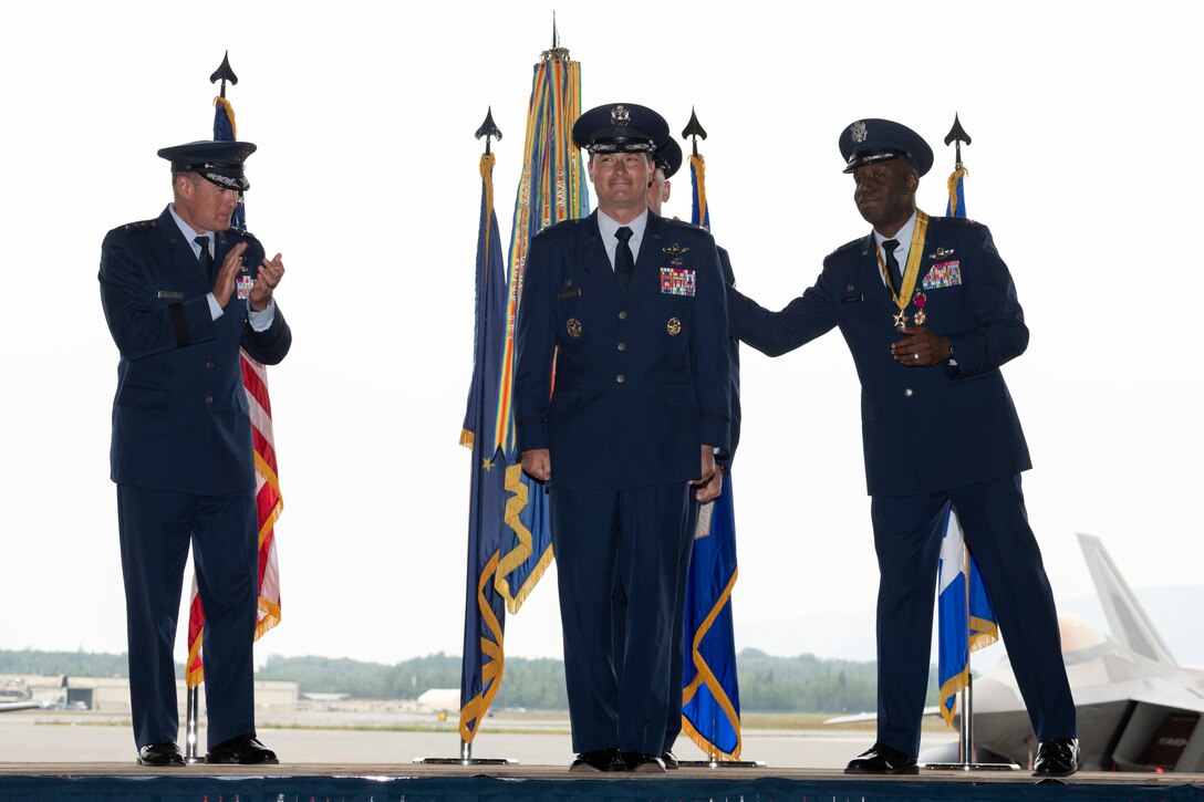 U.S. Air Force Col. Kevin M. Jamieson receives a round of applause while standing on stage