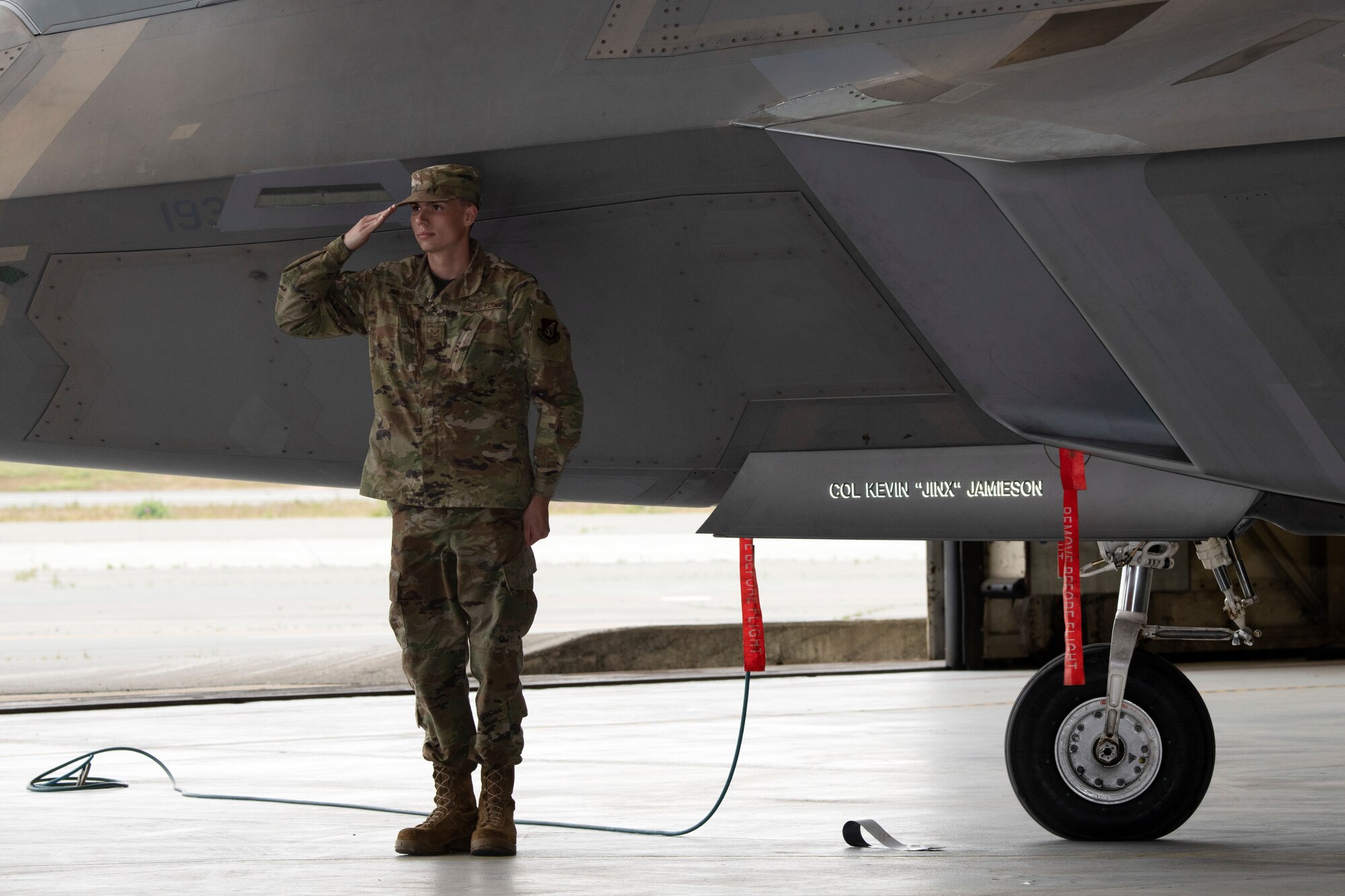 A U.S. airman salutes after revealing renamed F-22 fighter jet