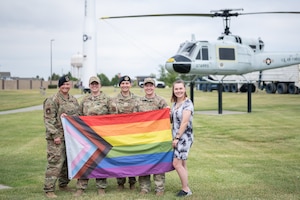 Members of the Malmstrom LGBTQ+ Initiative Team pose for a photo with a Progress Pride Flag July 13, 2022, at Malmstrom Air Force Base, Mont.