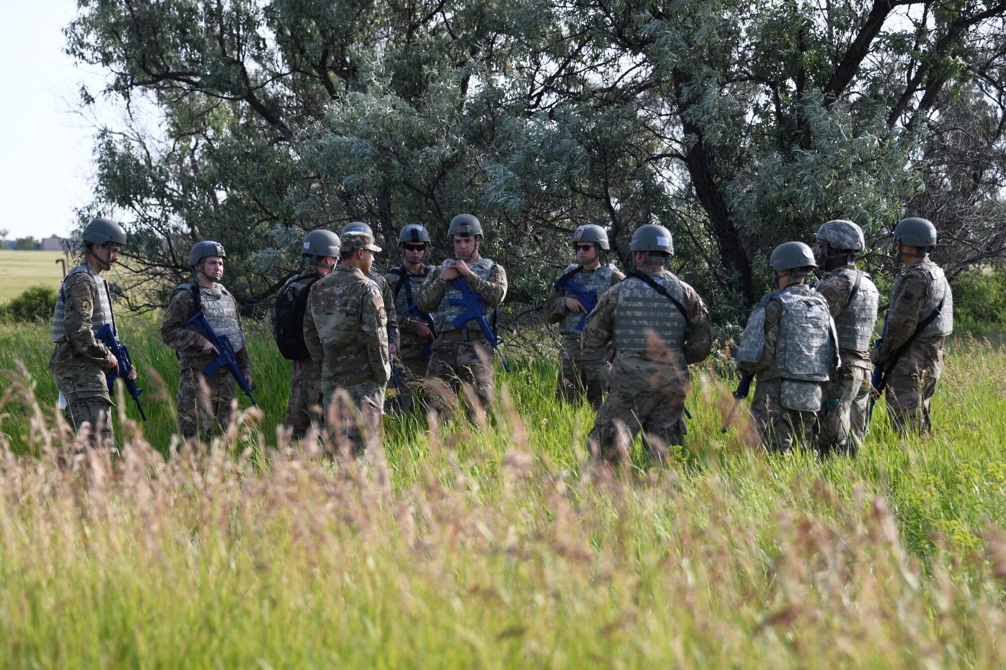 Airmen from the 319th Civil Engineer Squadron gather to discuss operations during a Prime Base Engineer Emergency Force training on Grand Forks Air Force Base, North Dakota, July 14, 2022. The Prime BEEF training allowed Airmen to exercise and conduct operations down range, which included hands-on training such as land navigation, troop movement, and tactical combat casualty care. (U.S. Air Force photo by Senior Airman Ashley Richards)